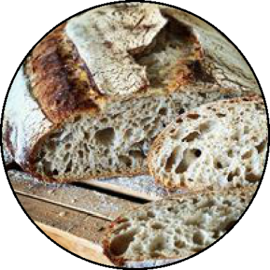 Freshly baked loaf of bread, sliced to reveal a soft, airy interior and crusty exterior.